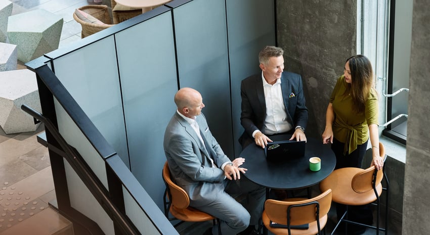 3 people sitting around a table working